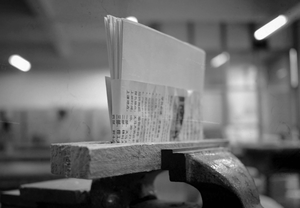 Folded page signatures held upright in a vise