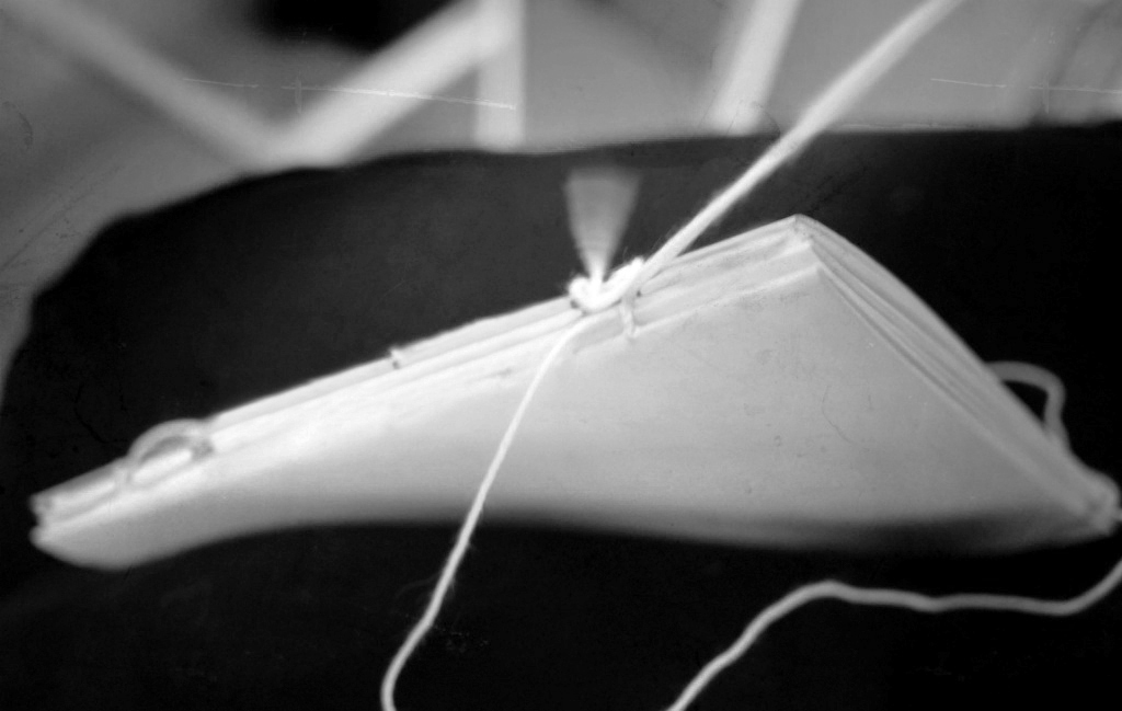 Thread passing through the folded signatures during hand sewing