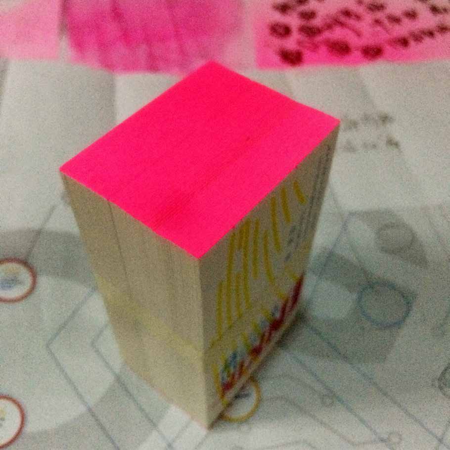 Small paper prototype with striped graphics and a fluorescent pink edge